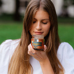 Femeie ținând un borcan de cremă Alunette cu cacao
